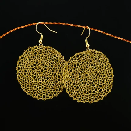 Runde Klöppelspitze-Ohrringe, auf weißem Hintergrund, mit feinen Details.